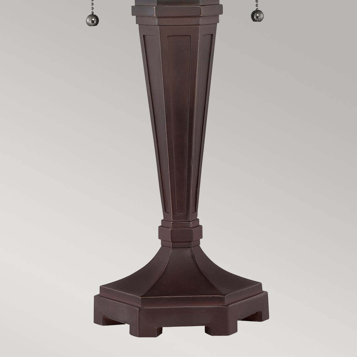 Vue rapprochée du pied bronze cannelé et de sa base octogonale