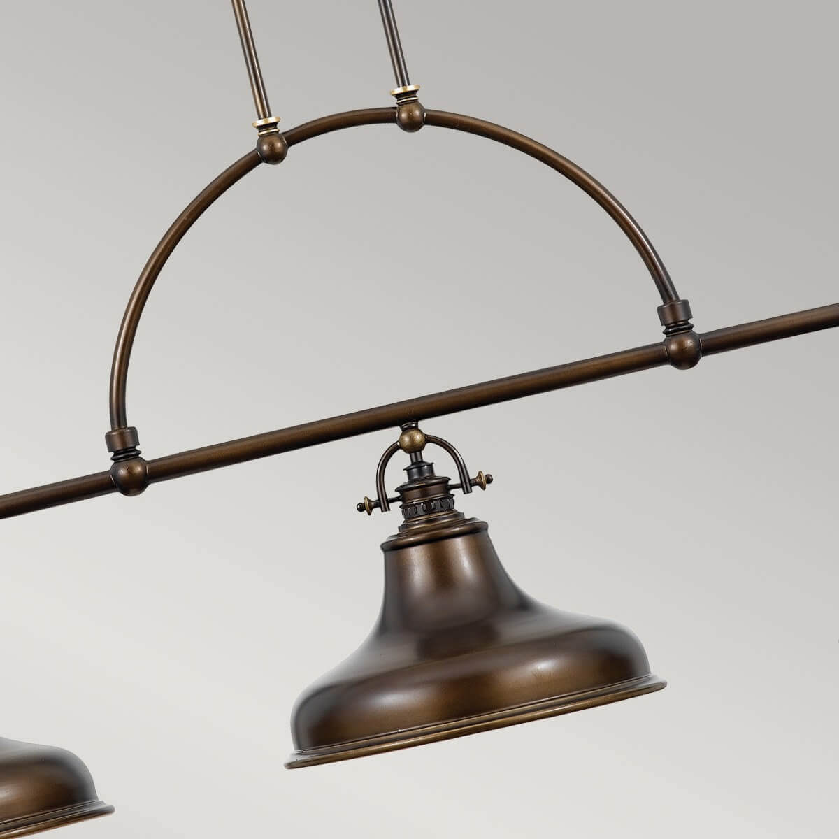 Gros plan sur l'arche centrale et l'abat-jour en métal patiné, finition bronze.