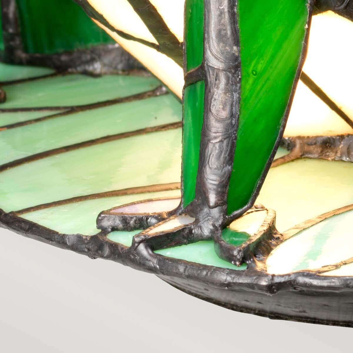 Détail des pattes avant posées sur la feuille, verre éclairé et finition bronze