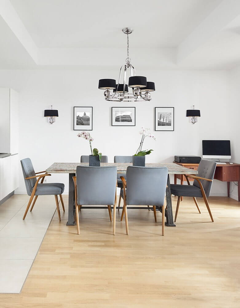 Mise en ambiance dans une salle à manger blanche, lustre suspendu au-dessus de la table
