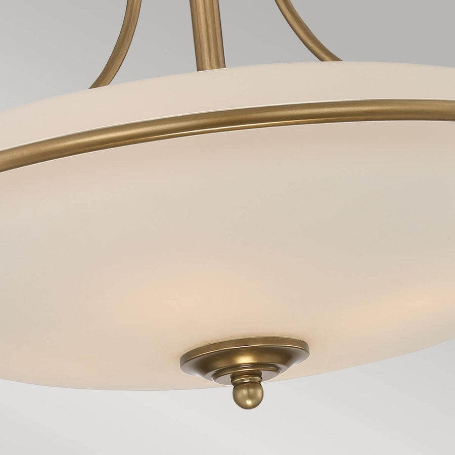 Détail du bas du luminaire avec la bille décorative en laiton sous le verre.