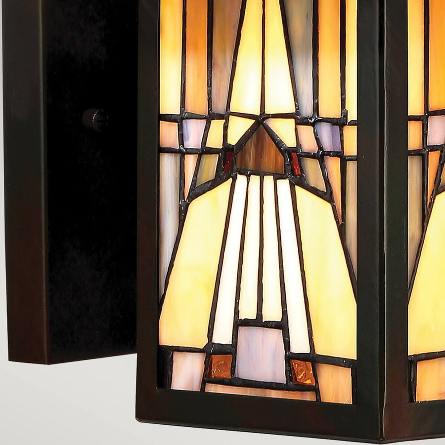 Gros plan du verre tiffany géométrique éclairé et de la platine murale.