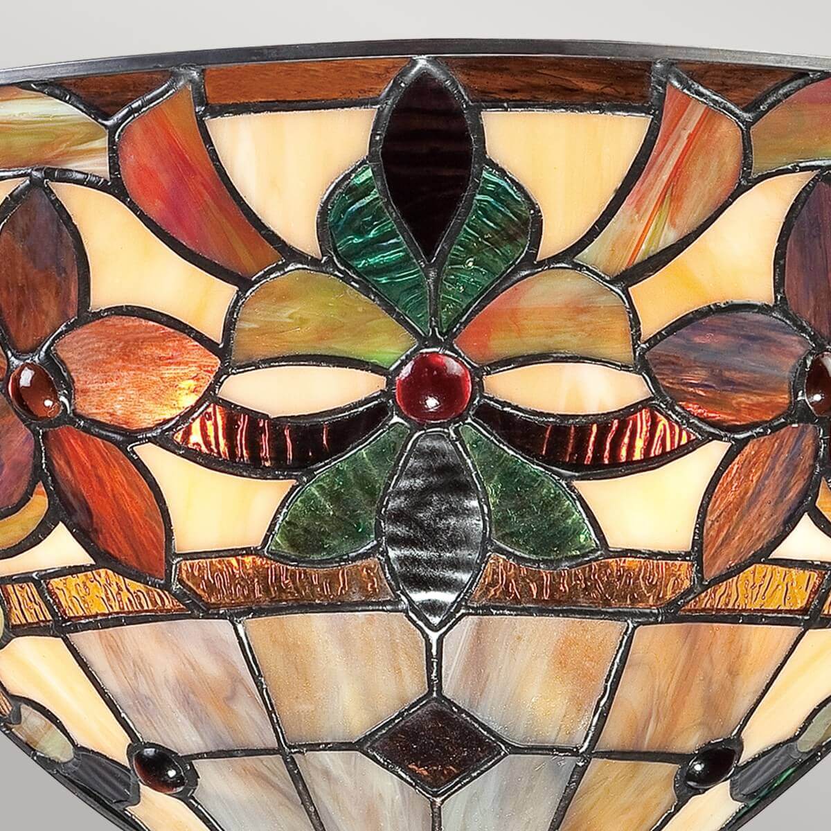 Gros plan sur la fleur centrale en verre vert et cabochon rouge
