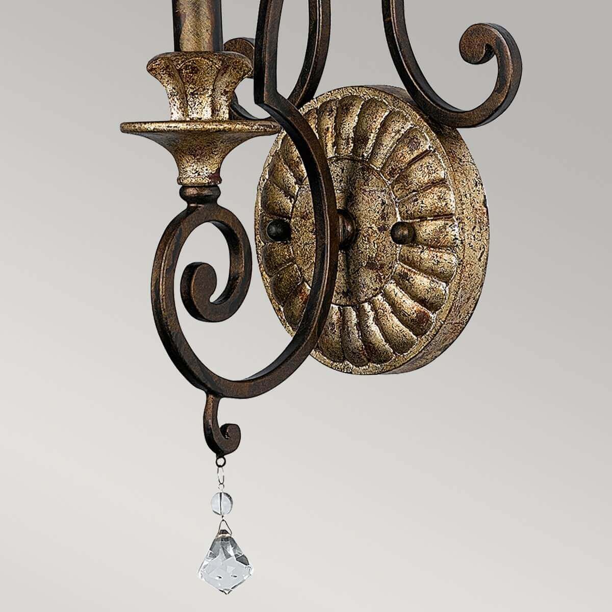 Vue rapprochée du bas de l'applique avec pampille cristal et volute terminale.