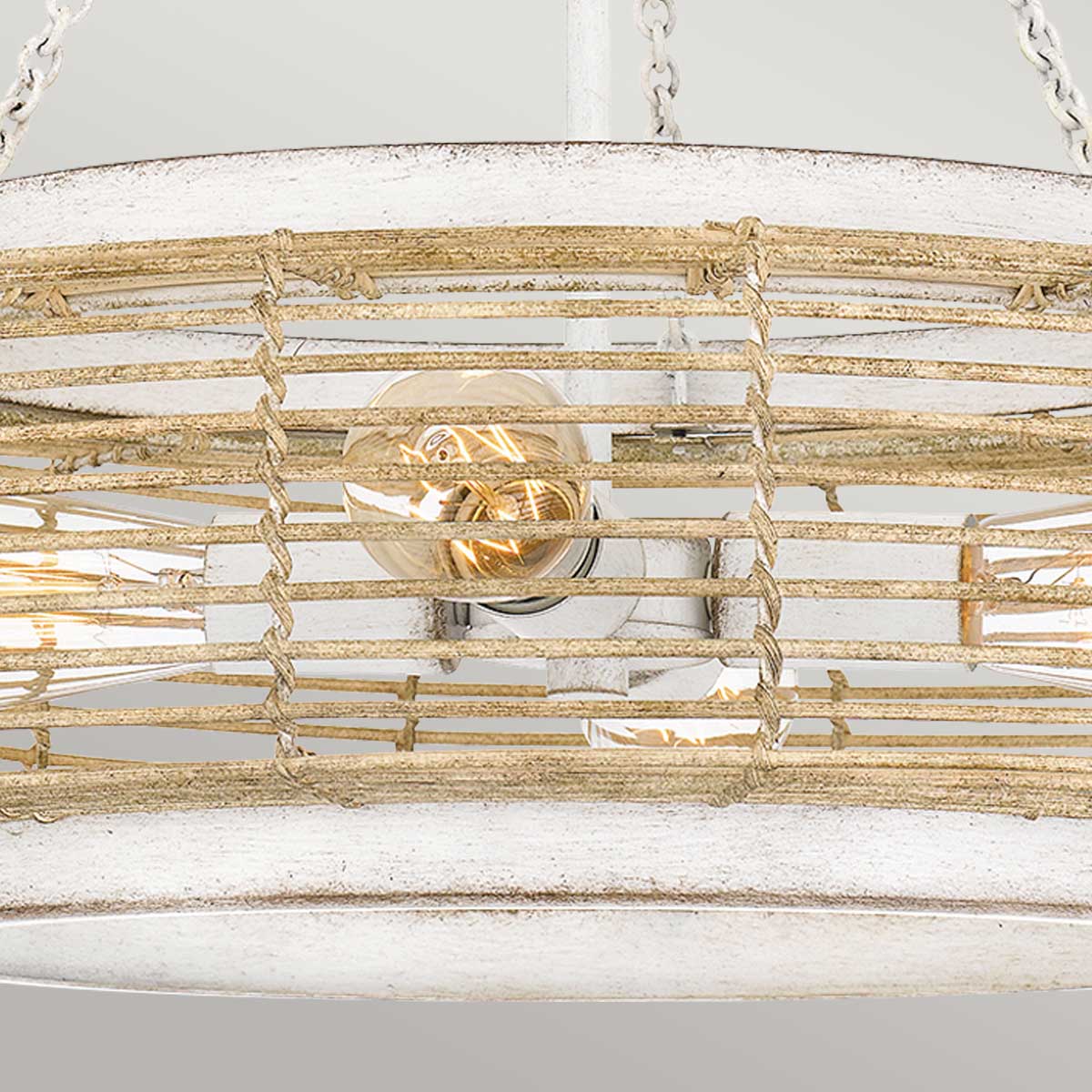 Détail central du luminaire avec douilles, ampoules en verre et croisillons en cannage.