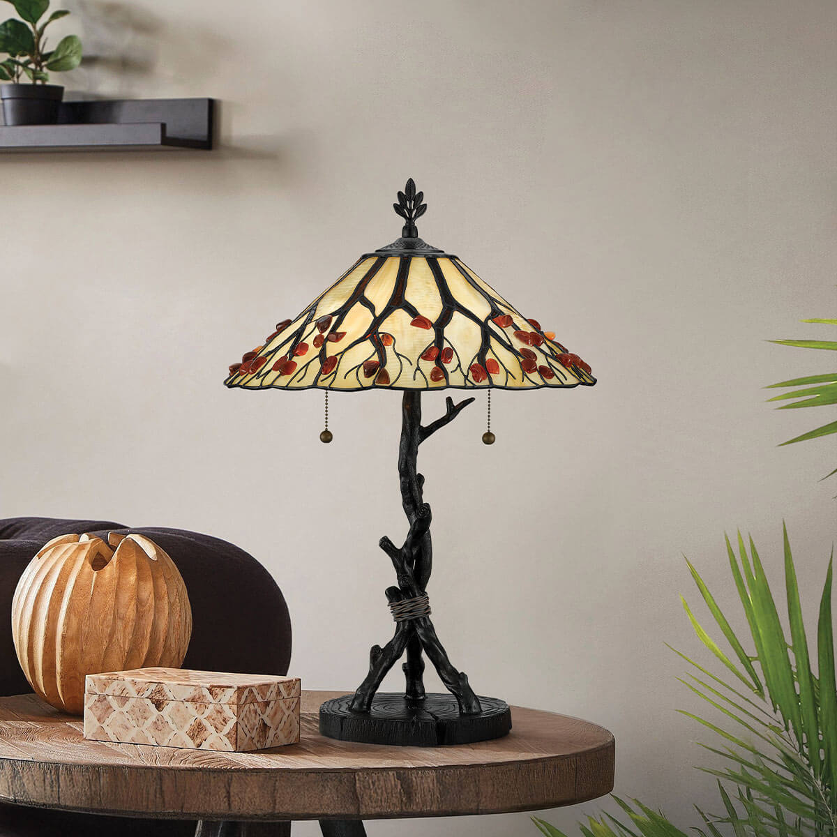 Mise en ambiance, lampe posée sur une table ronde en bois près d'une boîte