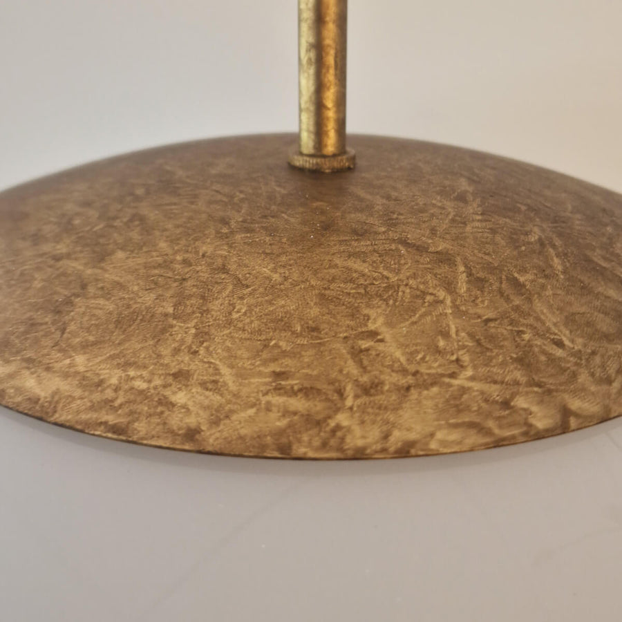 Détail de la rosace dorée martelée et de sa tige de fixation