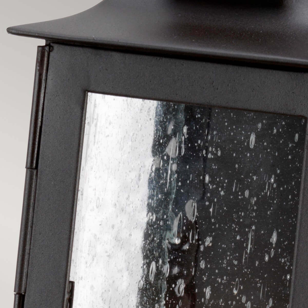 Gros plan sur le verre moucheté, les gouttes d'eau et la structure métallique.