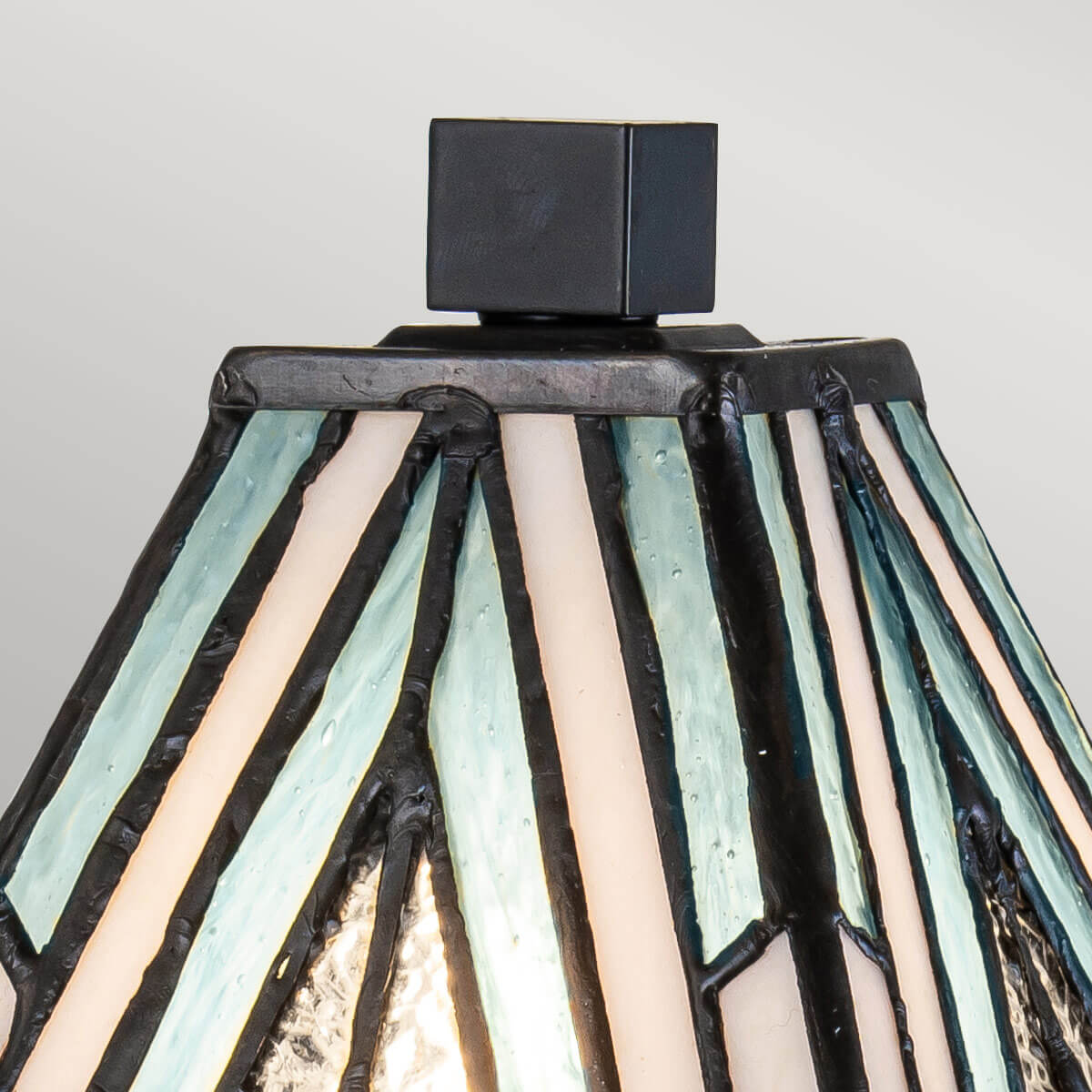 Détail du sommet : petit cube noir posé sur l'abat-jour en verre