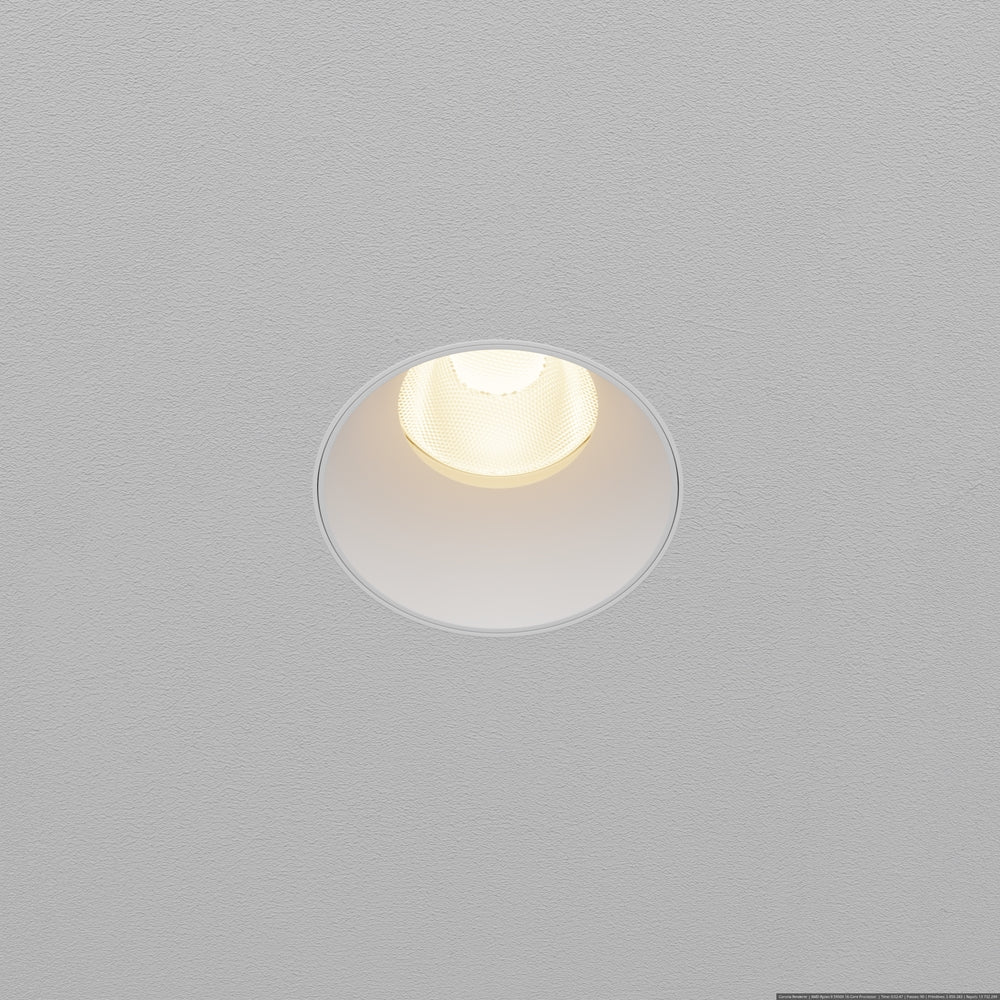 Spot encastré rond blanc allumé, vu de dessous dans un plafond gris texturé