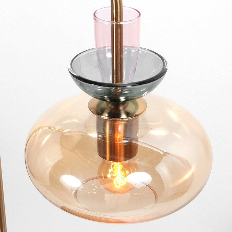 Détail du verre coloré empilé et de l’ampoule chaude au centre du luminaire.