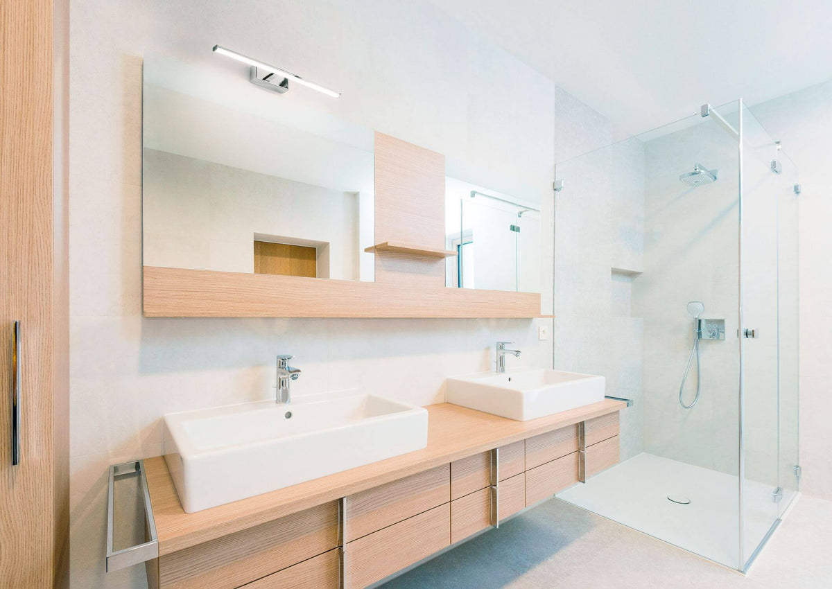 Mise en ambiance au-dessus d'un miroir de salle de bain moderne en bois clair