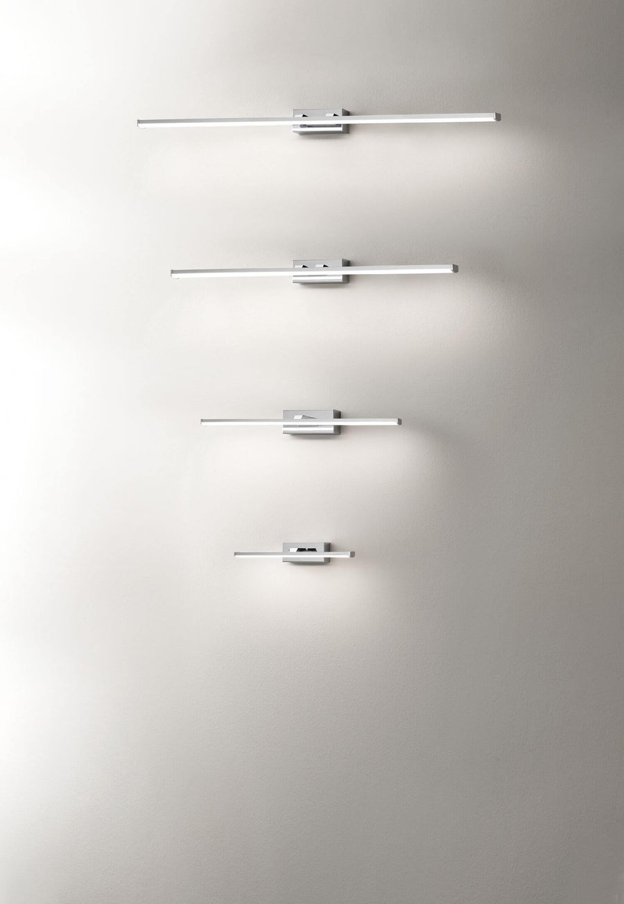 Quatre appliques blanches de tailles croissantes alignées verticalement sur un mur clair