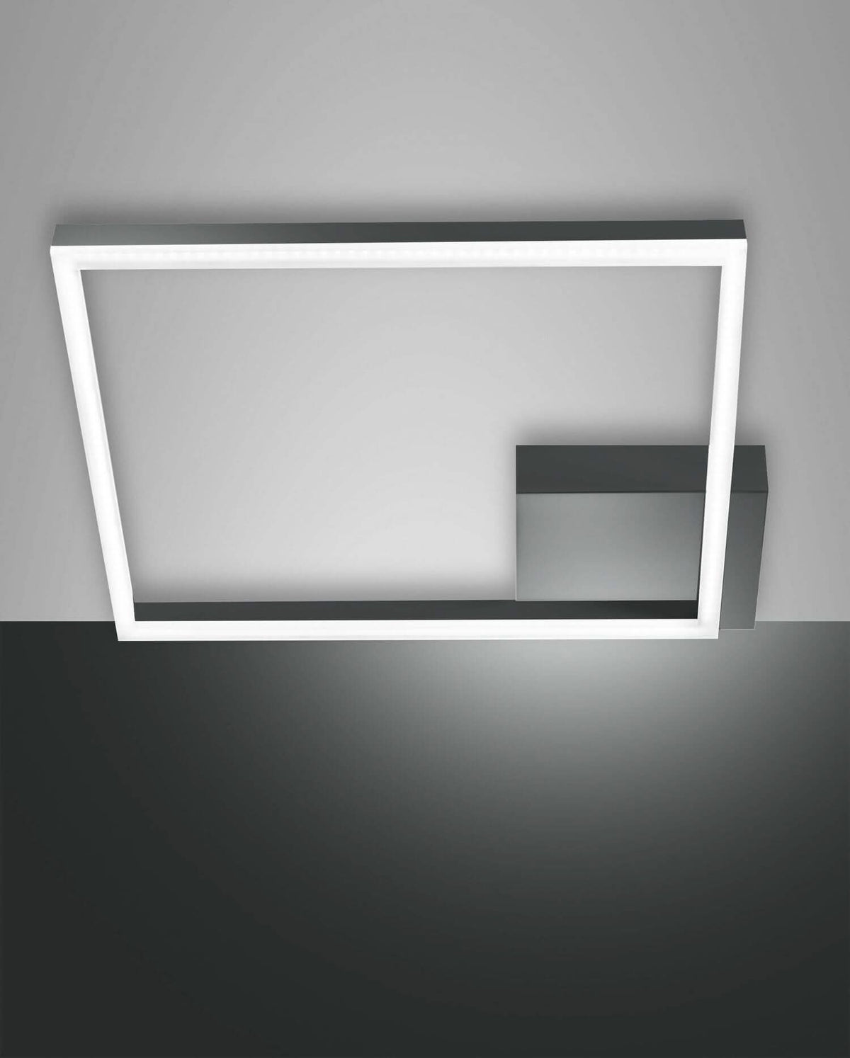 Plafonnier rectangulaire anthracite vu de trois quarts, cadre lumineux et boîtier central apparent