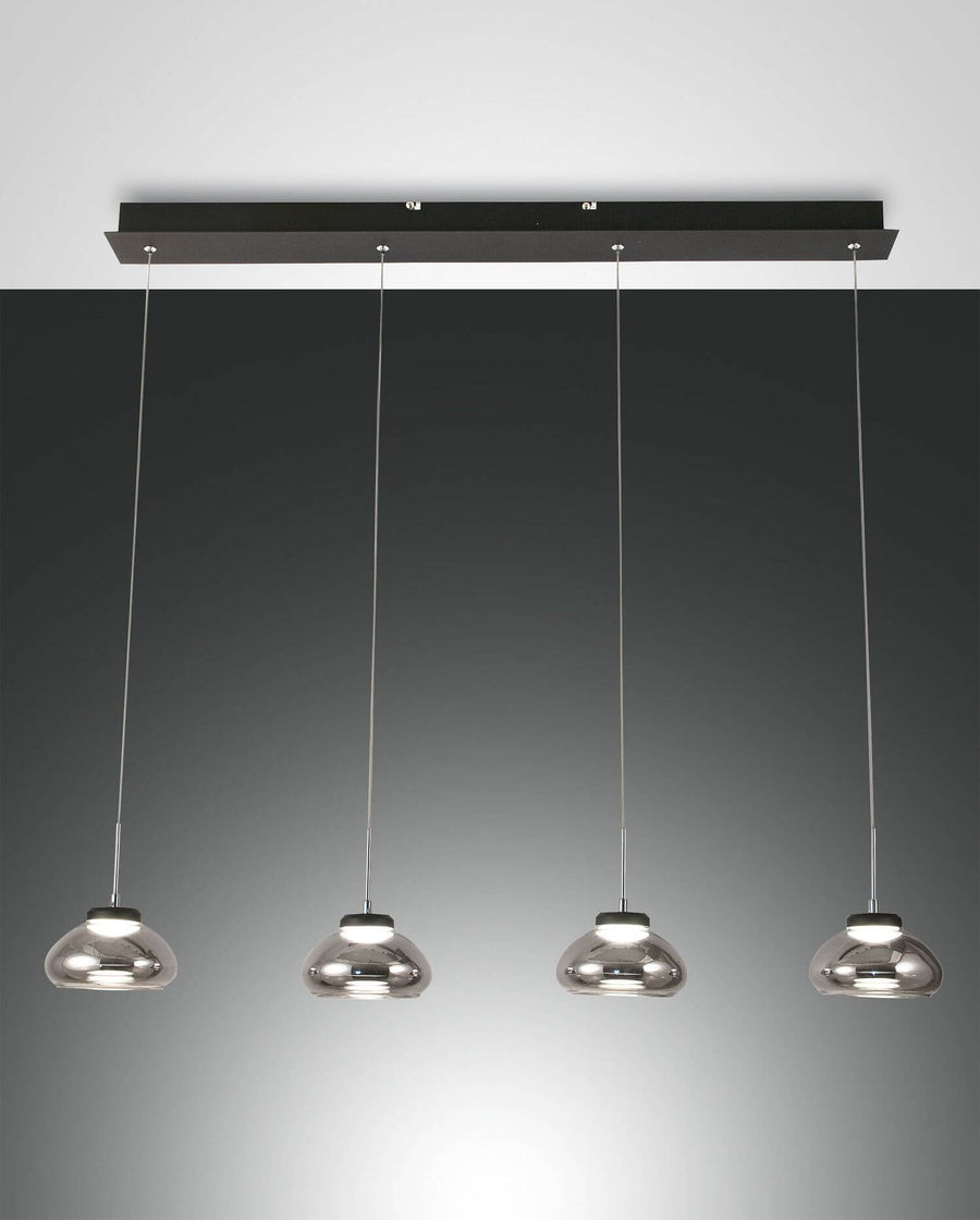 Suspension quatre lumières en verre fumé, barre noire fixée au plafond, vue de face.