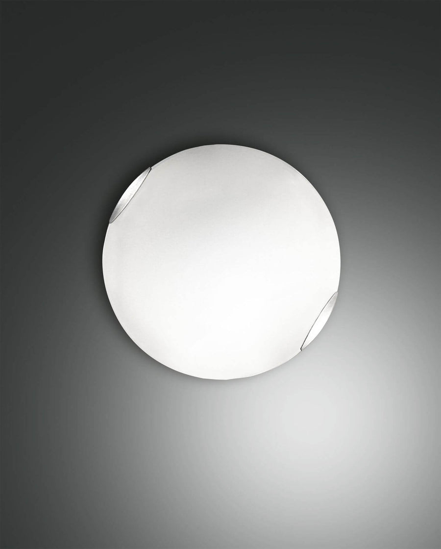 Plafonnier rond blanc de face, verre opalin et fixations métalliques visibles sur le pourtour