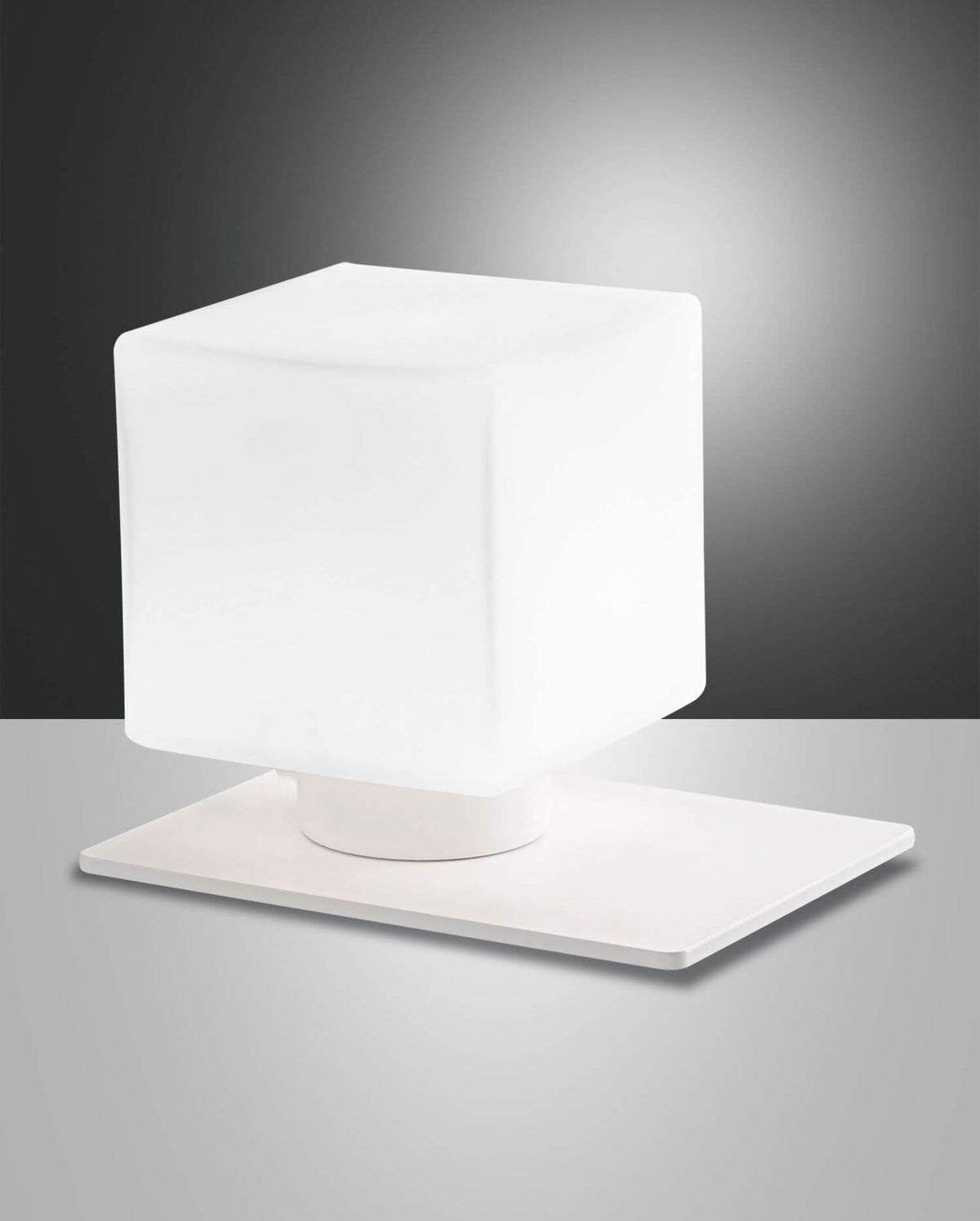 Lampe à poser blanche cubique sur socle carré, présentée de face sur fond gris.