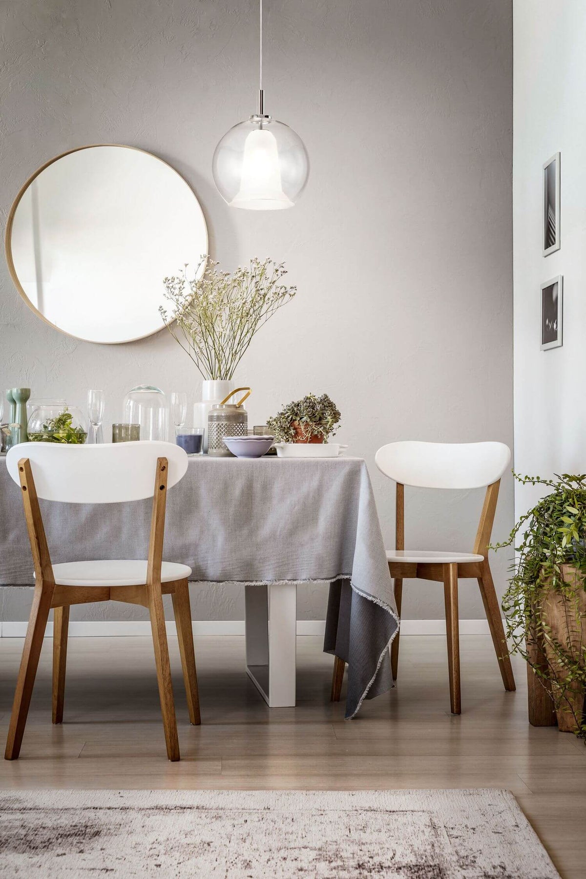 Mise en ambiance au-dessus d'une table grise avec chaises en bois clair.