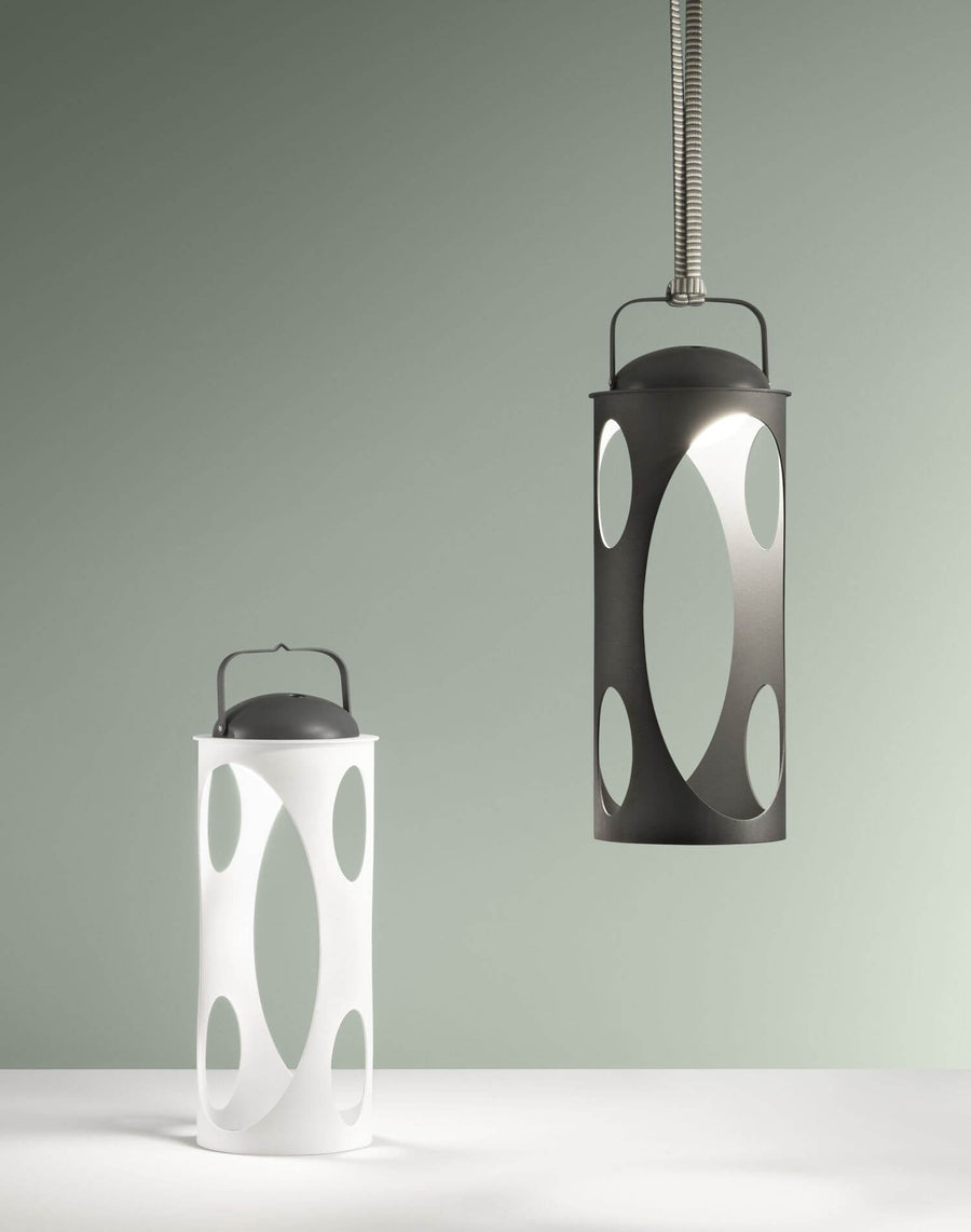 Comparatif : lampe blanche posée et version noire suspendue à un câble.