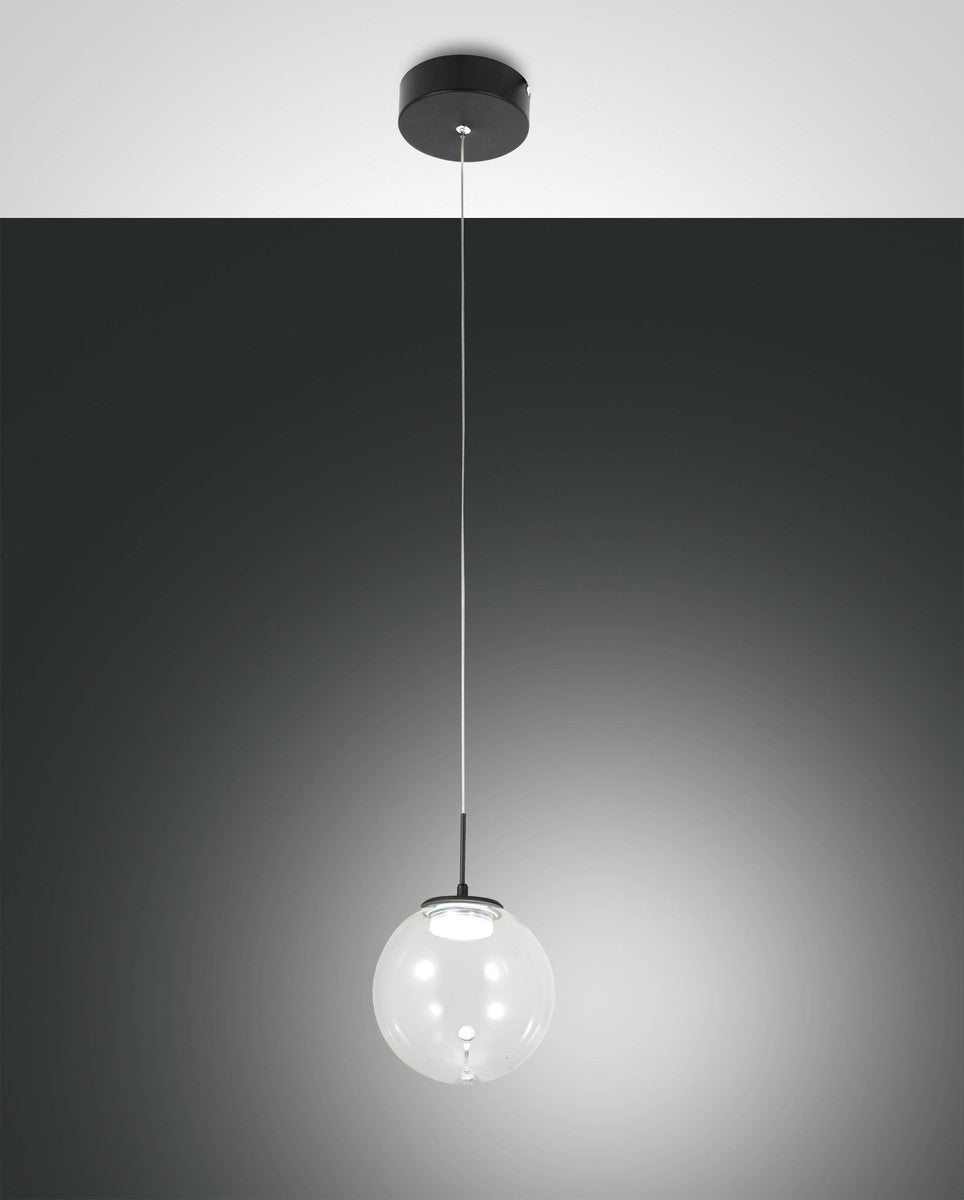 Suspension au globe de verre transparent allumé, vue de face sur fond gris dégradé