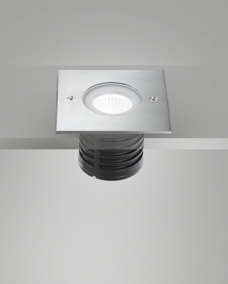 Luminaire encastré dans une surface grise, vue par-dessous avec optique allumée