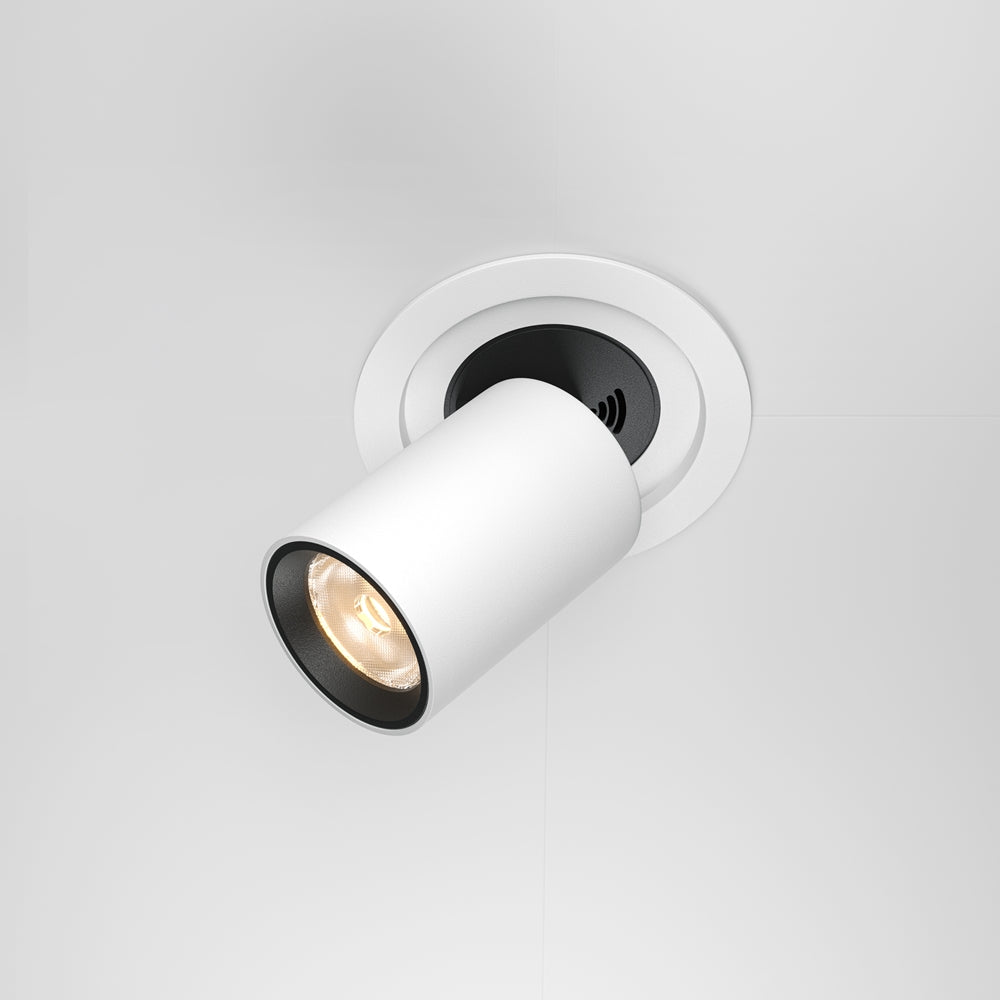 Spot encastré blanc orientable vu de trois quarts, tête cylindrique inclinée et allumée