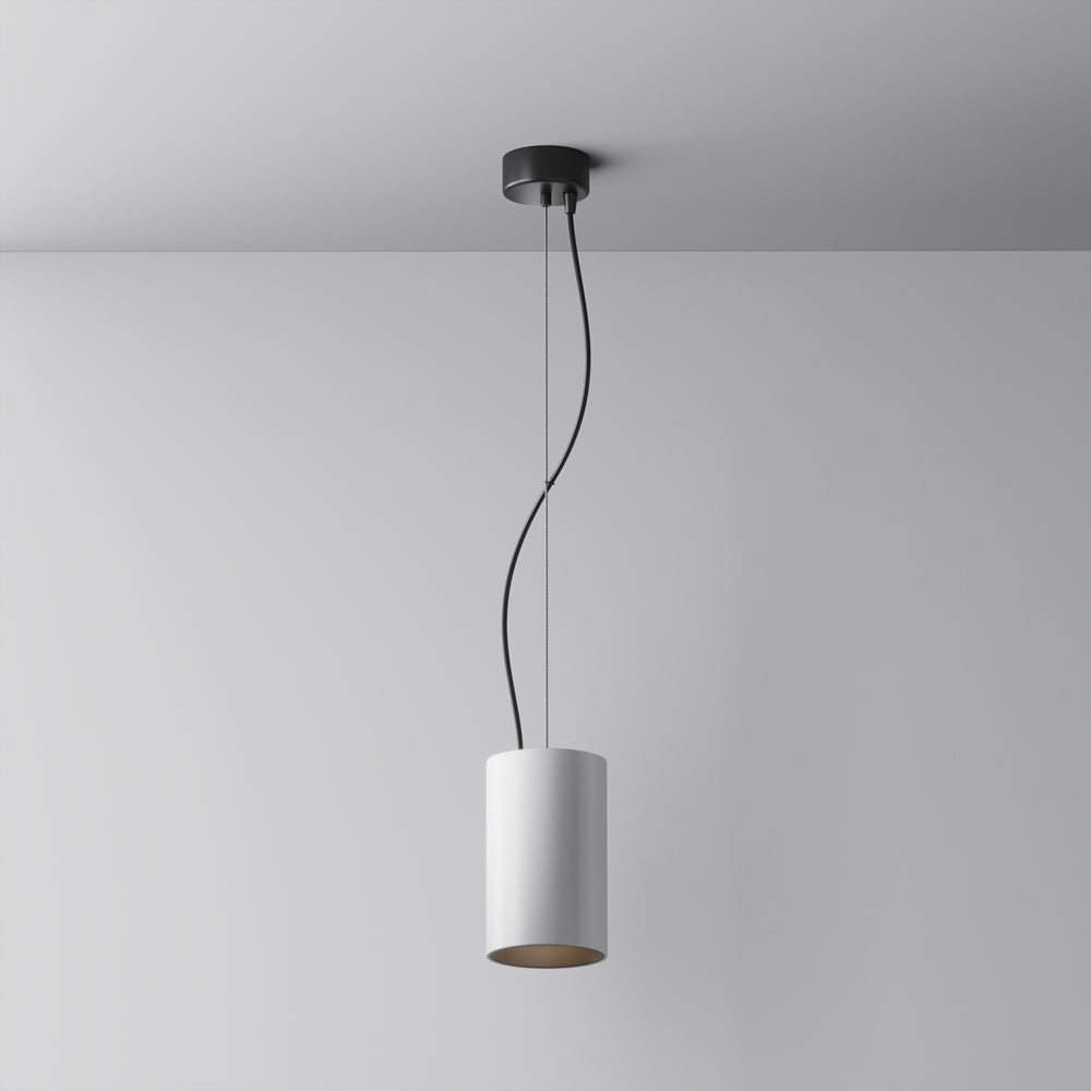 Vue de face d'une suspension blanche cylindrique suspendue devant un mur gris clair
