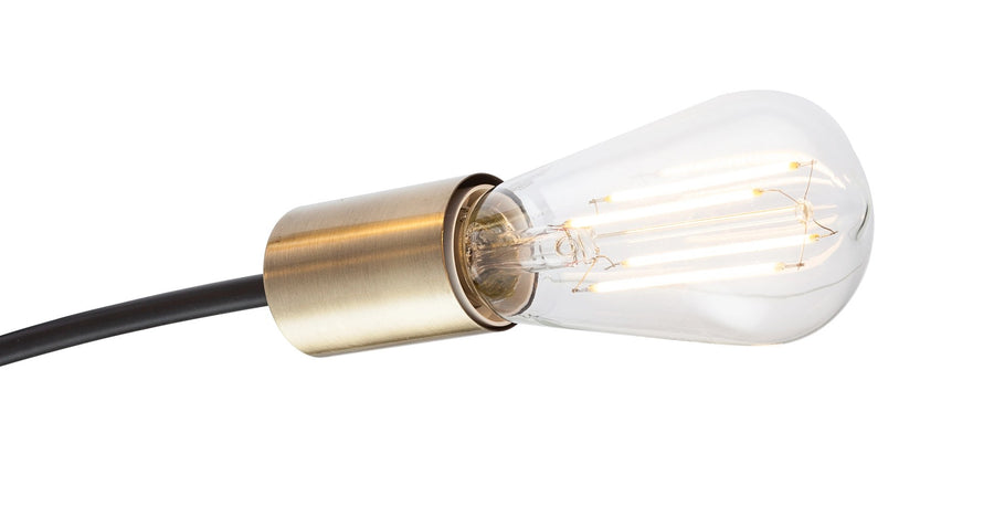 Gros plan sur la douille laiton brossé et l'ampoule transparente