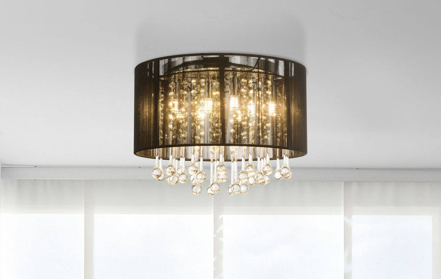 Plafonnier installé au plafond blanc, éclairé, montrant son contour cylindrique et ses cristaux scintillants en intérieur.