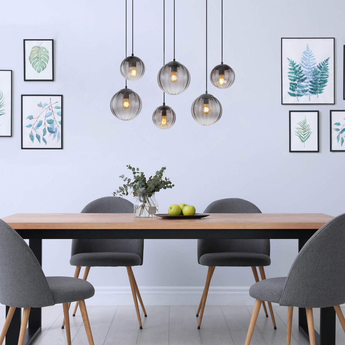 Mise en ambiance au-dessus d'une table à manger en bois avec chaises grises.