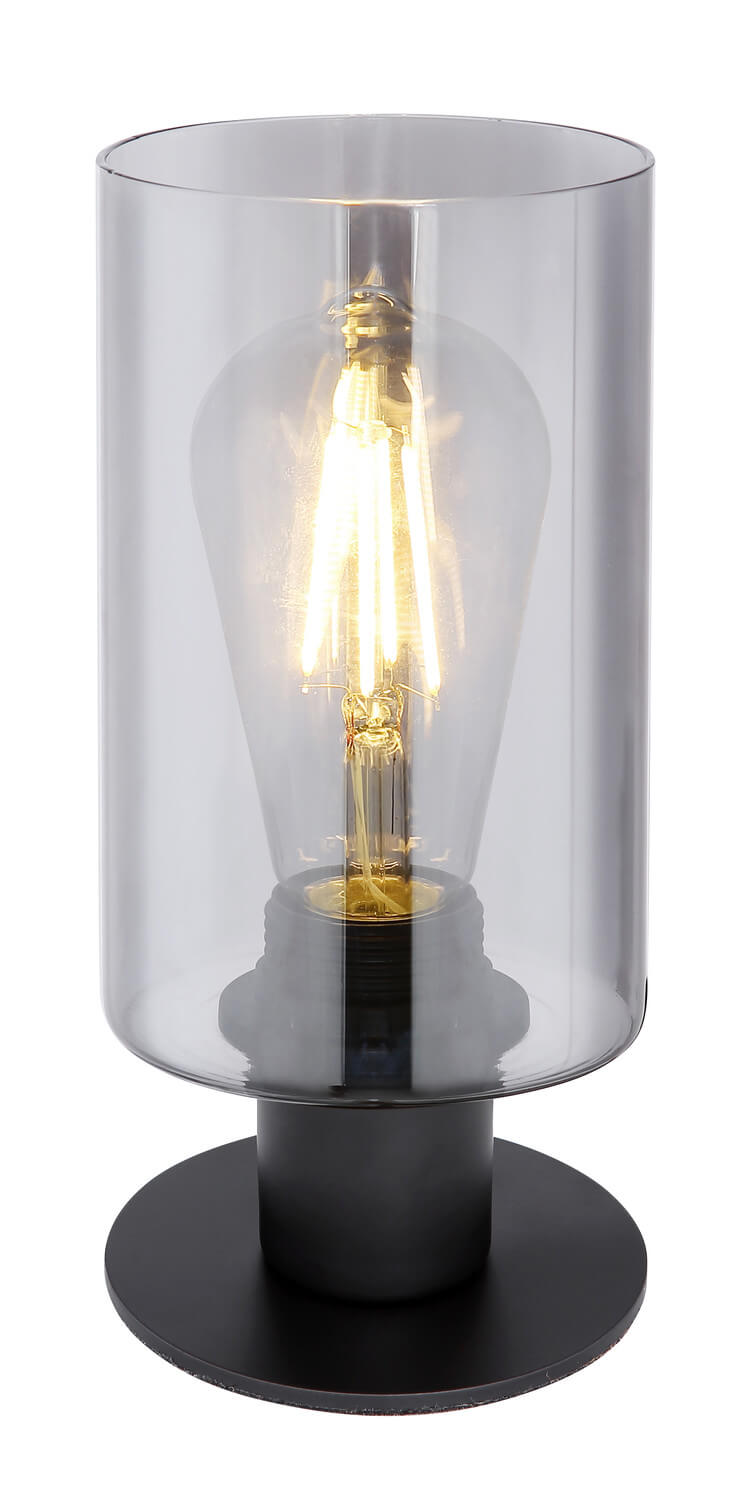 Gros plan sur l'abat-jour cylindrique en verre et l'ampoule à filament allumée.