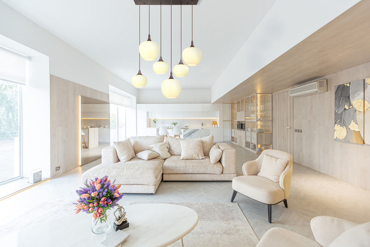 Mise en ambiance dans un salon moderne clair, luminaire suspendu au plafond