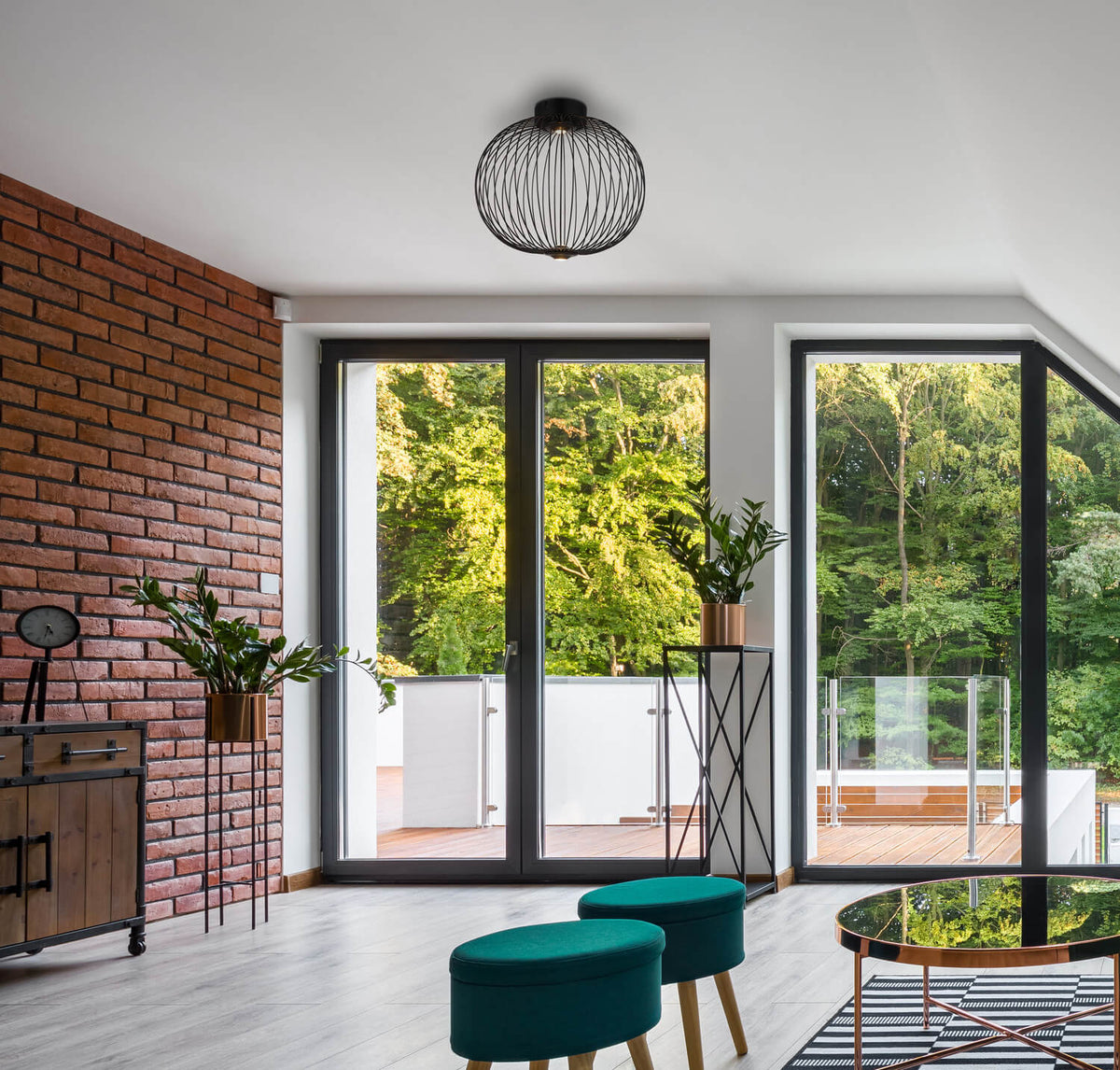 Plafonnier fixé au plafond blanc d'un salon moderne ouvert sur le jardin