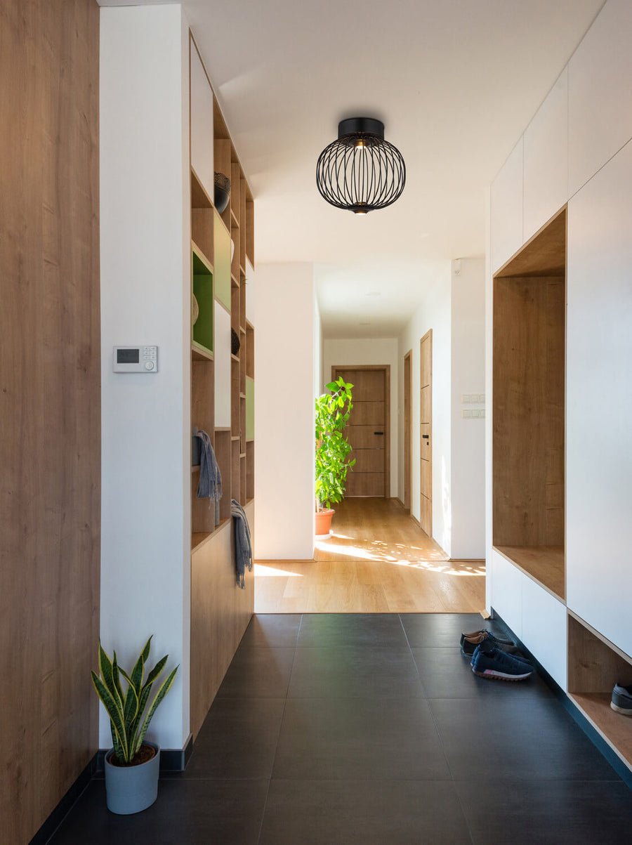 Mise en situation du luminaire allumé dans un couloir d'entrée clair et contemporain