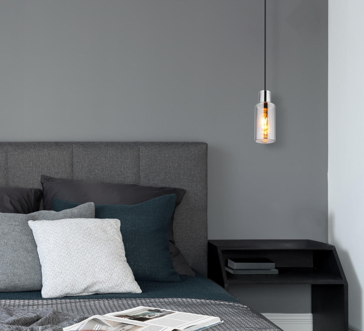 Mise en ambiance dans une chambre, suspension allumée au-dessus d'une table de chevet.
