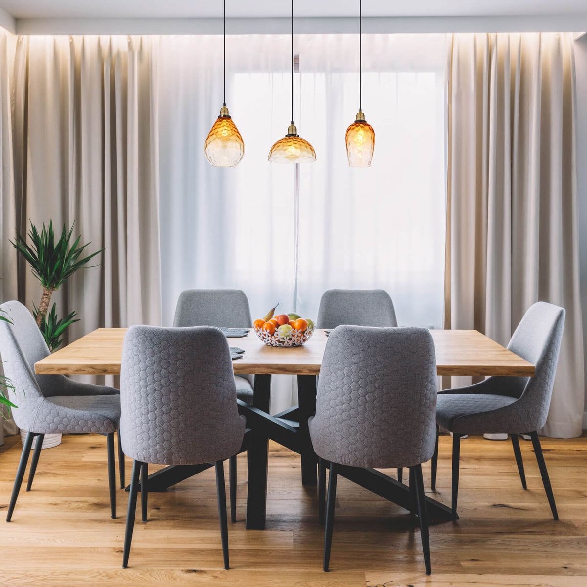 Mise en ambiance au-dessus d'une table à manger en bois avec chaises grises.