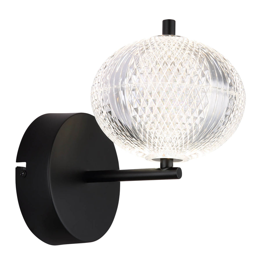 Vue de trois quarts du luminaire éteint, globe en verre taillé et base ronde noire.