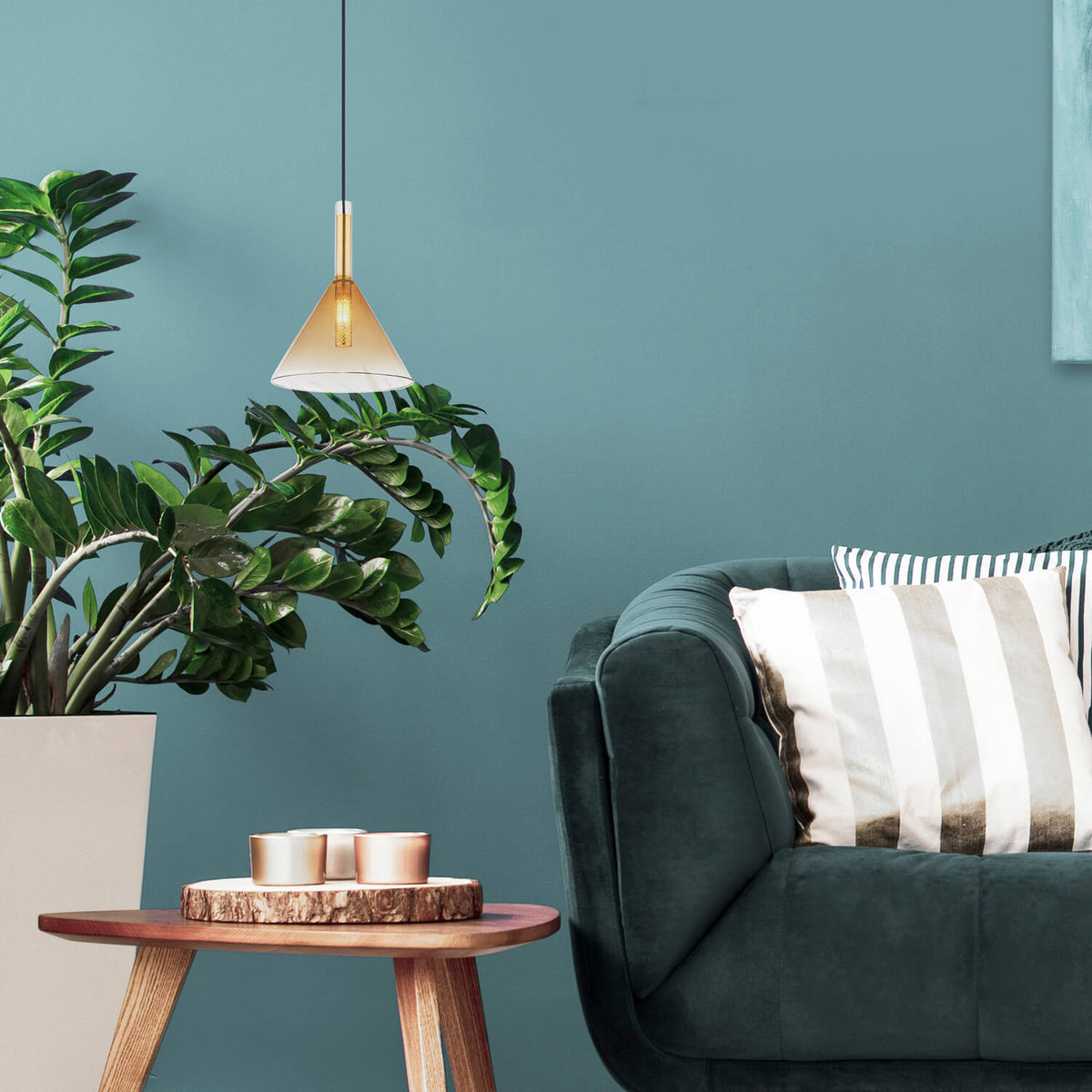 Mise en ambiance avec plante verte, canapé et table basse sous la suspension
