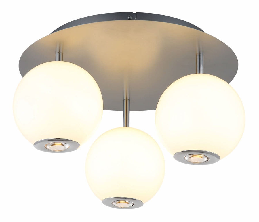 Plafonnier allumé diffusant une lumière chaude à travers les trois globes de verre