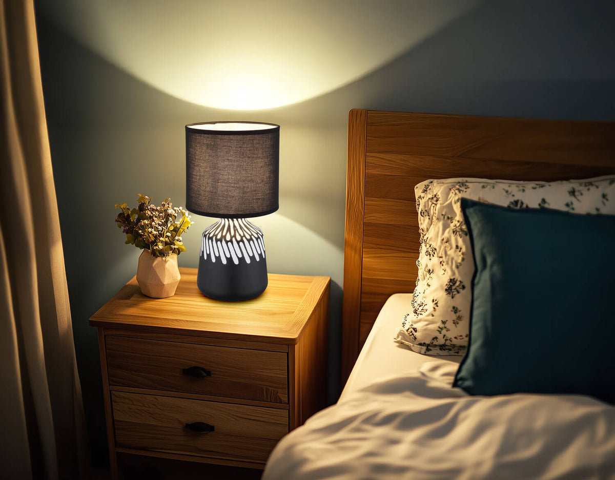 Mise en ambiance de la lampe allumée sur une table de chevet en bois