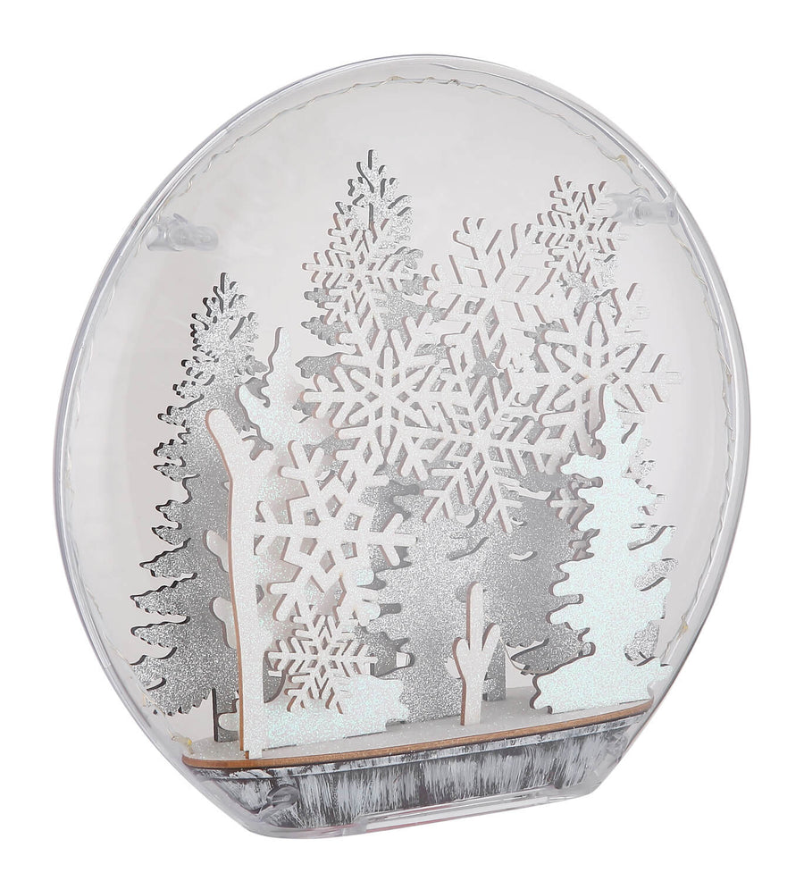 Vue rapprochée du luminaire transparent éteint, détaillant la silhouette des arbres et le socle.