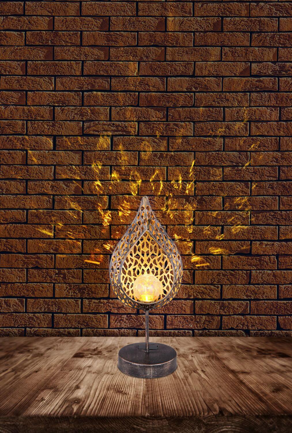 Mise en ambiance sur table en bois devant mur de briques, motifs lumineux projetés