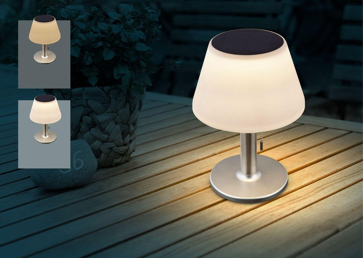 Mise en ambiance nocturne : lampe allumée sur une table en bois, près d'une plante