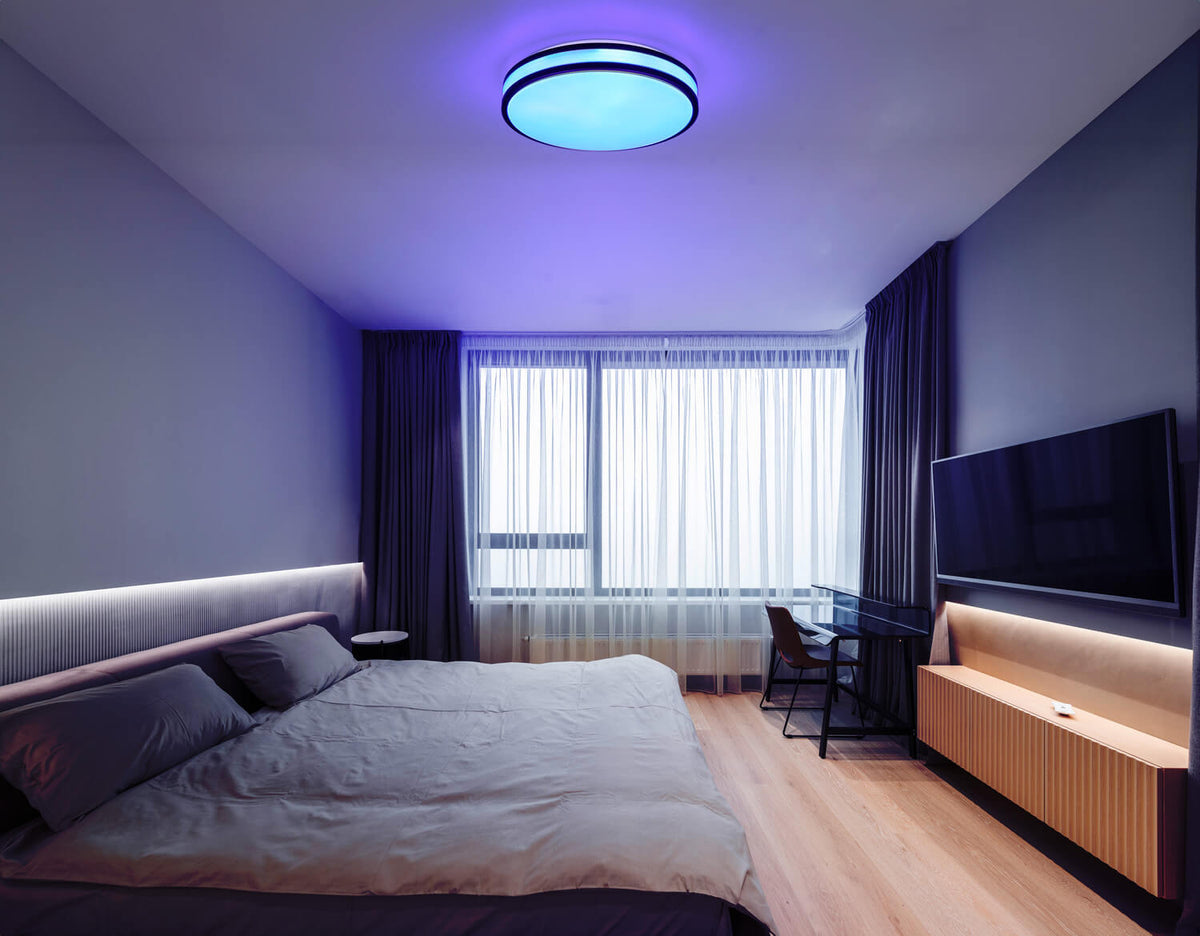 Mise en ambiance dans une chambre, plafonnier allumé en lumière bleue et violette