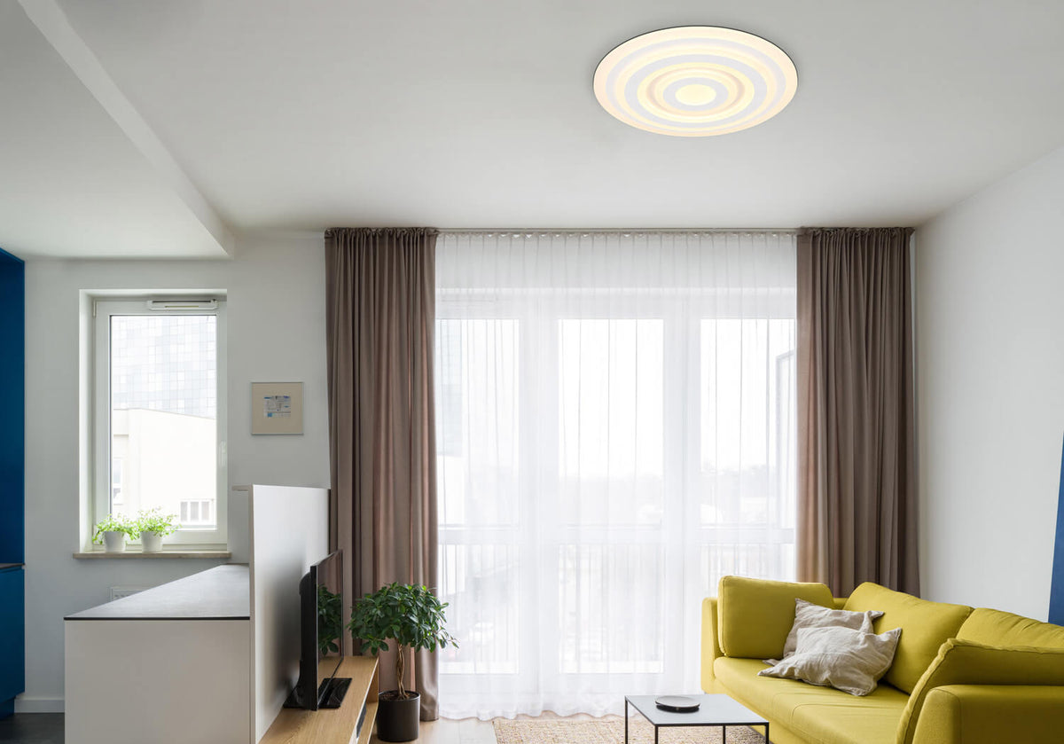 Mise en ambiance dans un salon moderne, plafonnier blanc fixé au plafond