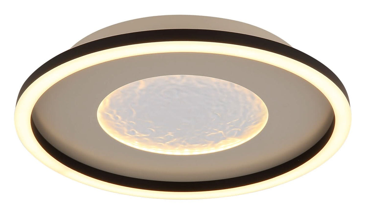 Plafonnier allumé, anneau périphérique lumineux et halo chaud au centre texturé.