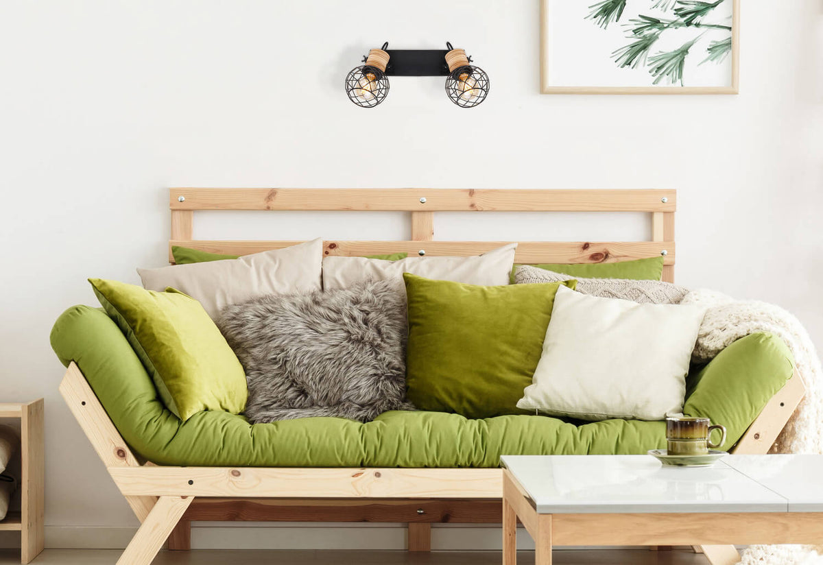 Mise en ambiance murale au-dessus d'un canapé vert avec coussins et cadre.
