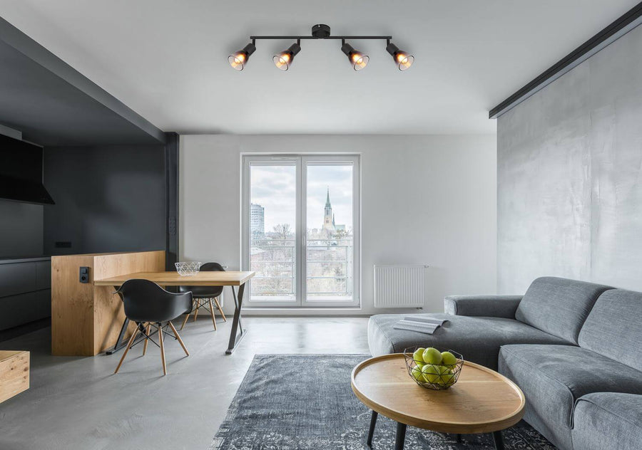 Mise en ambiance dans un séjour, plafonnier noir orientable à quatre spots.