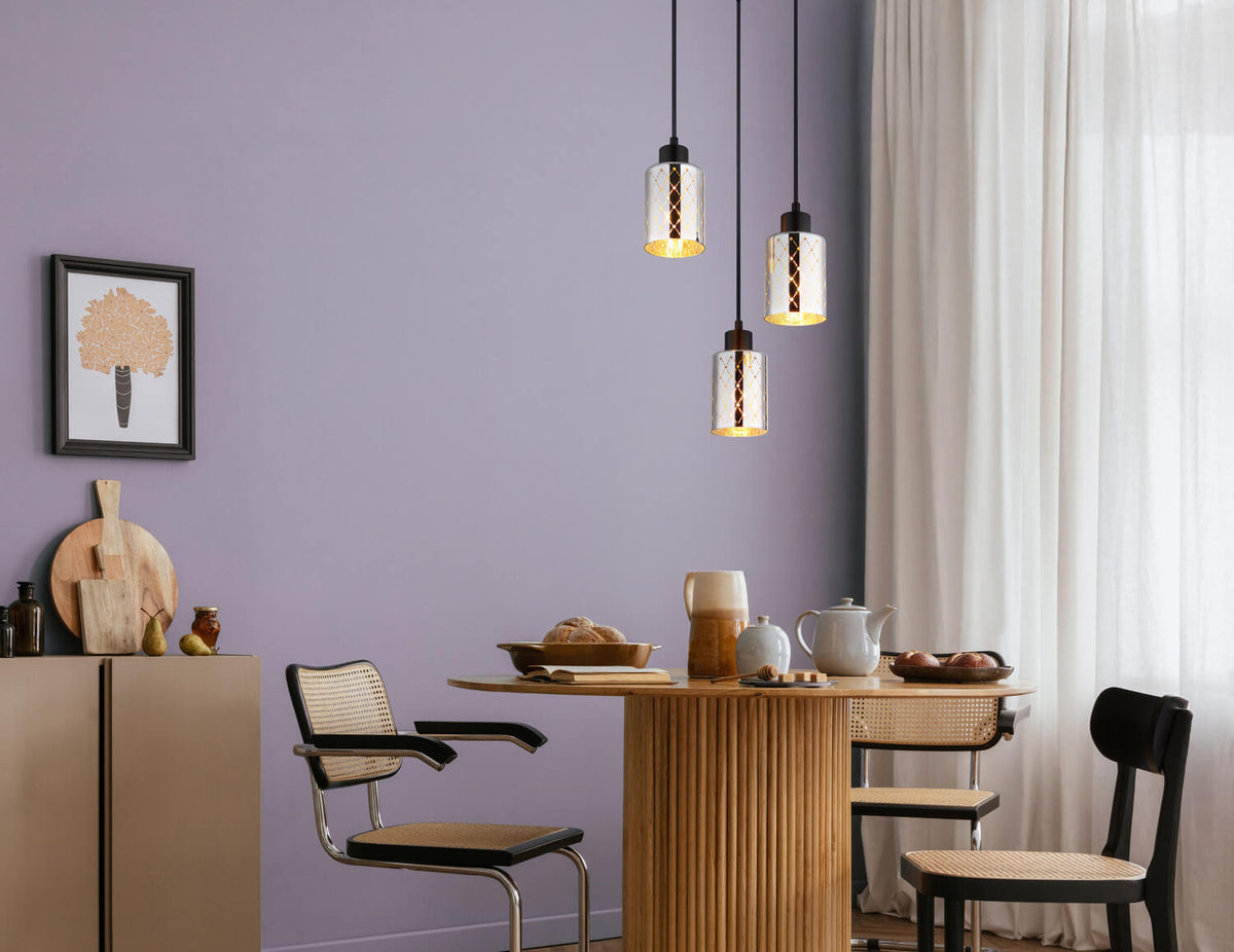 Mise en ambiance au-dessus d'une table, suspension noire à trois abat-jours en verre