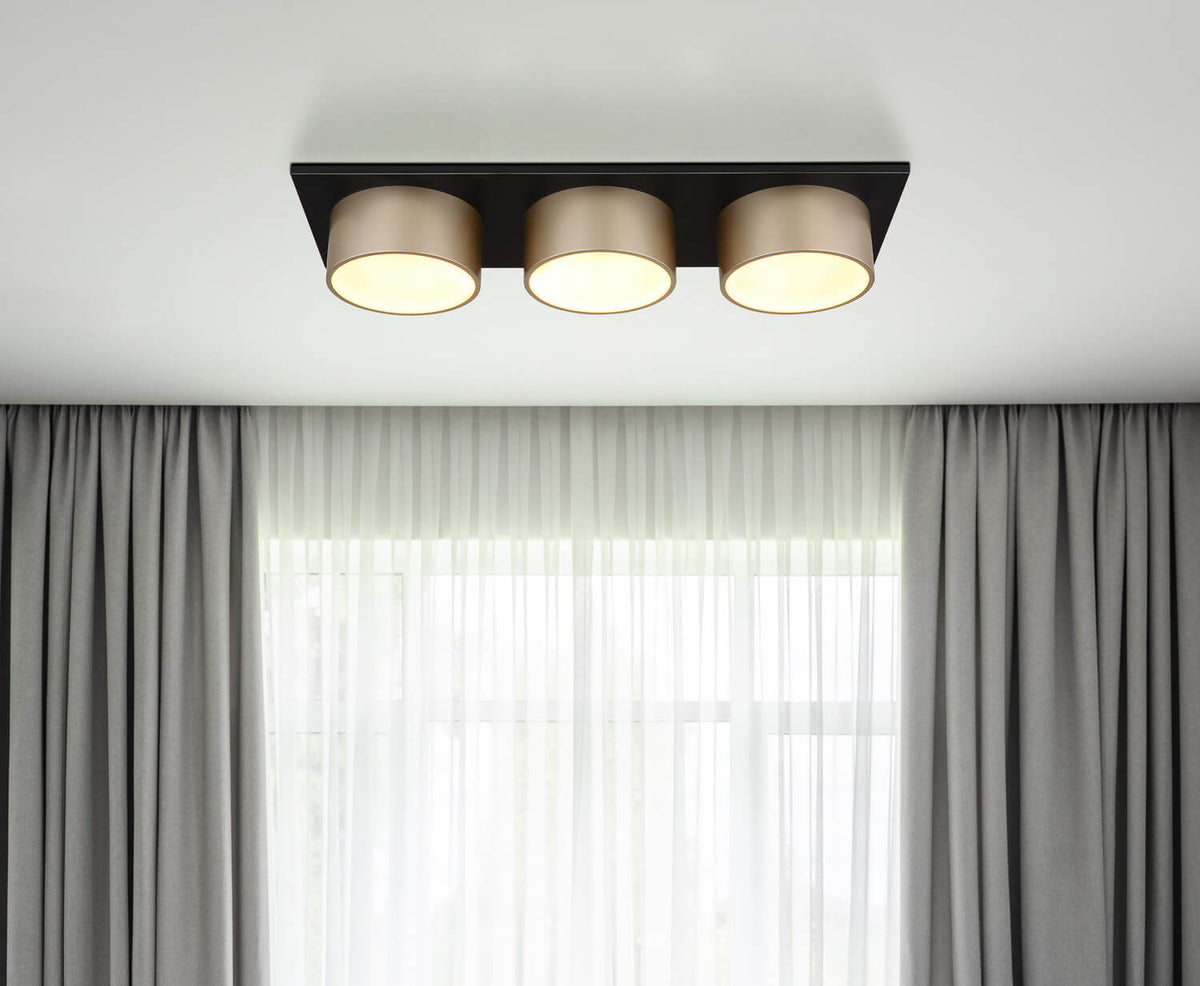Mise en ambiance au plafond devant fenêtre à rideaux gris, lumière allumée